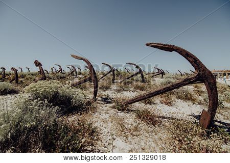 Natural Cemetery Of Marine Anchors At Barril Beach On The Southern Portuguese Coast Of The Atlantic.