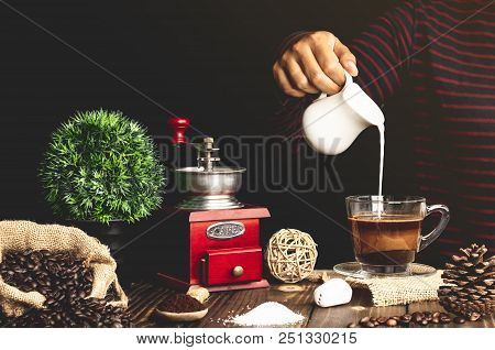 Coffee With Pouring Milk In Glass On A Wooden