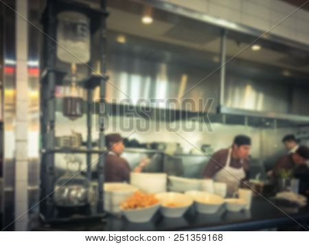 Blurred Background Chef Preparing For Lunch Service In Asian Restaurant Kitchen
