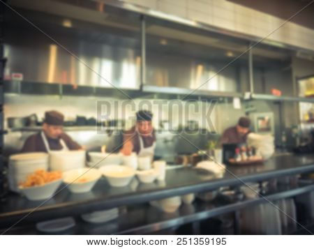Blurred Background Chef Preparing For Lunch Service In Asian Restaurant Kitchen