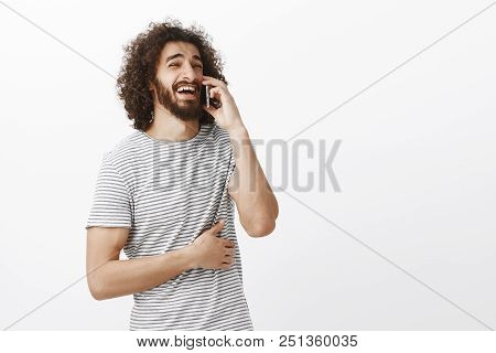 Indoor Shot Of Joyful Attractive Boyfriend With Beard And Afro Hairstyle, Looking Aside While Talkin