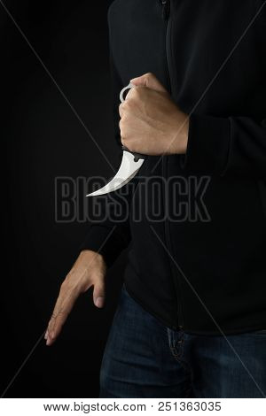 Crime And Violence Concept, A Murderer With A Karambit Knife Trying To Kill Victim