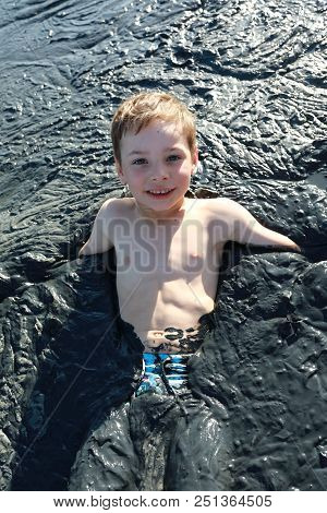 Child Lying In Healing Mud