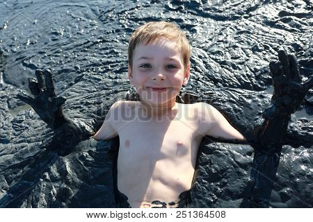 Boy Lying In Healing Mud