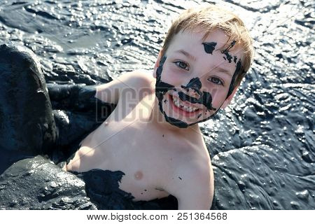 Kid Lying In Healing Mud, Primorsko-akhtarsk, Russia