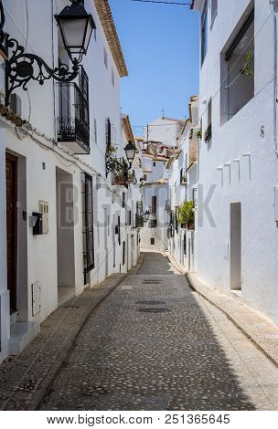 Picturesque Narrow Street With White Houses In Village Of Altea, Alicante, Spain. Travel And Vacatio