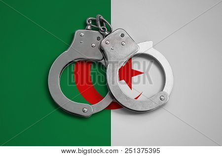 Algeria Flag  And Police Handcuffs. The Concept Of Observance Of The Law In The Country And Protecti