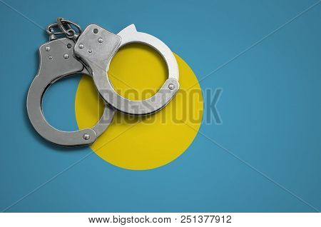 Palau Flag  And Police Handcuffs. The Concept Of Crime And Offenses In The Country.