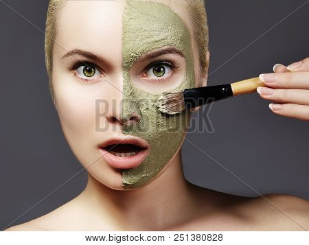 Beautiful Woman Applying Green Facial Mask. Beauty Treatments. Close-up Of Spa Girl Apply Clay Facia