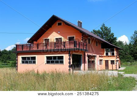 New Suburban Family House With Two Large Garages And Wide Open Balcony Surrounded With High Uncut Gr