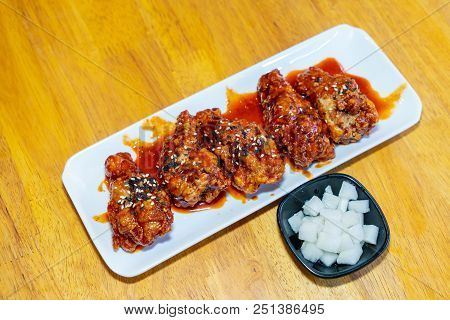 Spicy Korean Chicken Wings In White Plate On Wooden Table