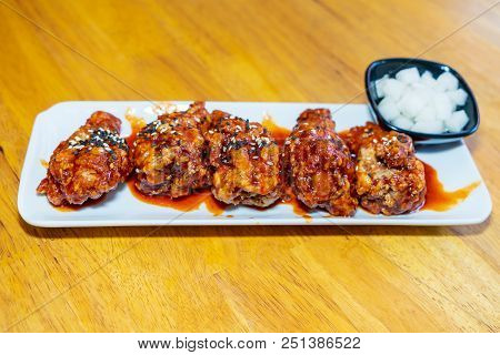Spicy Korean Chicken Wings In White Plate On Wooden Table
