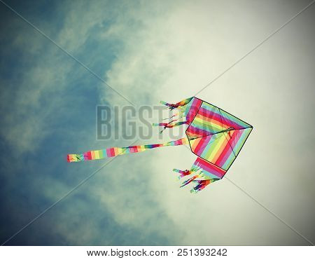 Big Kite With The Colors Of The Rainbow Flies High In The Blue Sky With Vintage Old Effect