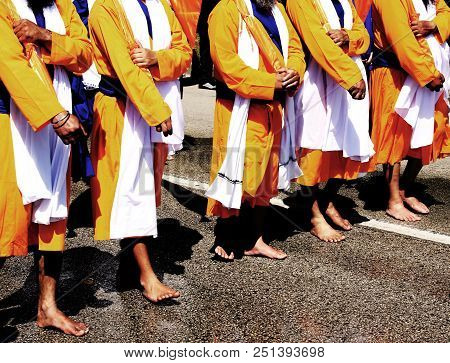 Sikh Soldiers Dressed In A Traditional Orange And White Dress With A Blue Belt Walk Barefoot During 