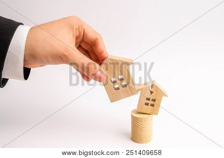 The Businessman's Hand Replaces The Old Broken House With A New One. Concept Of Renovation, Renovati
