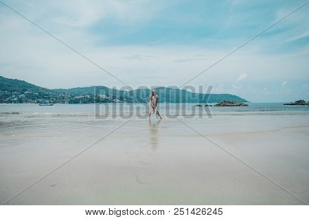 Handsome Girl On The Beach Background. Portrait Of A Woman In White Clothes On The Sea