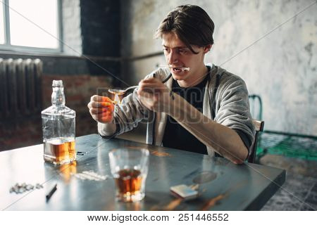 Drug addict with spoon and matches prepares a dose