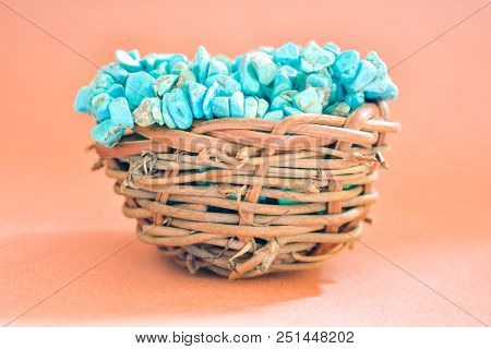 Pile Stones Of Raw Turquoise In Small Wooden Nest On A Brown Background. Blue And Green Color Stones