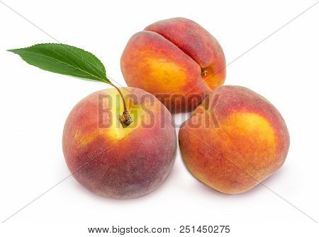 Three Ripe Fresh Peaches With Leaf On A White Background
