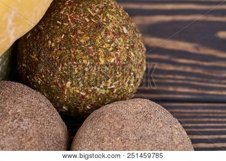 Round Heads Of Rustic Natural Cheese With Sice Lie On A Wooden Board