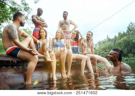 Enjoying Forest Party With Friends. Group Of Beautiful Happy Young Men And Girls Swimming At The Riv