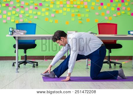 Man in the office with many conflicting priorities doing exercis