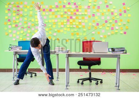 Man in the office with many conflicting priorities doing exercis