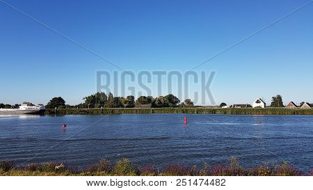 Red Buoys On The Water Of River Hollandsche Ijssel In The Netherlands With Blue Sky.