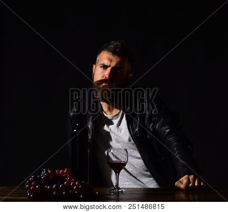 Man With Beard Near Glass Of Wine On Dark Brown Background. Winetasting And Degustation Concept. Som