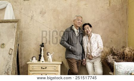 Happy Asian Senior Couple Casual Dress With Sunglasses In Vintage House