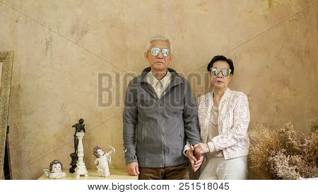 Happy Asian Senior Couple Casual Dress With Sunglasses In Vintage House