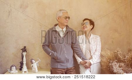 Happy Asian Senior Couple Casual Dress With Sunglasses In Vintage House