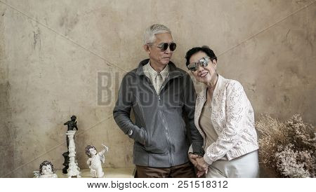 Happy Asian Senior Couple Casual Dress With Sunglasses In Vintage House
