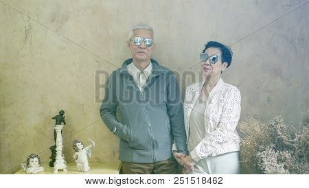 Happy Asian Senior Couple Casual Dress With Sunglasses In Vintage House