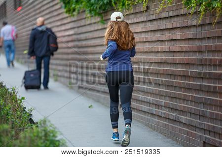 Young Woman Jogging Along The Street In Eurpean City In The Morning. Running Fitness Girl Against Br