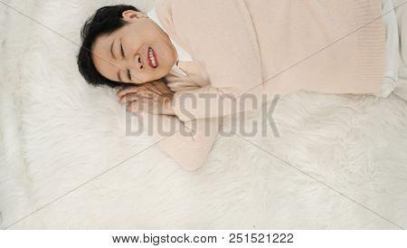 Asian Senior Woman Wear Pink Sweater Sleep On White Fur Bed