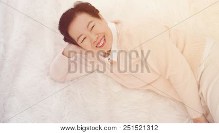 Asian Senior Woman Wear Pink Sweater Sleep On White Fur Bed