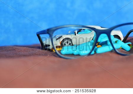 A Baby White Machine Unloads The Blue Capsules And Different Tablets On A Brown Surface Next To The 