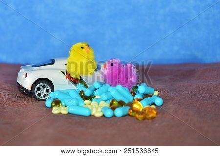 Children's White Typewriter Small Toys, Different Pills On A Brown Surface On A Blue Background. The