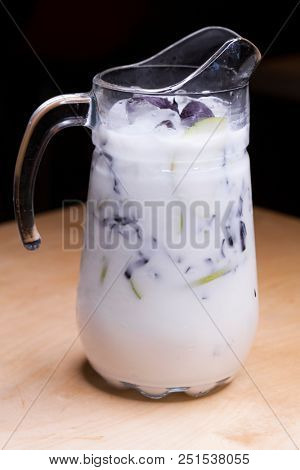 Ayran - liquid drink made from yogurt in ransparent glass cup and green apple