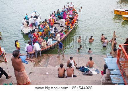VARANASI, UTTAR PRADESH, INDIA - JULY 6, 2018: Boats with pilgrims arriving at ceremonies Dasashvamedh Ghat 