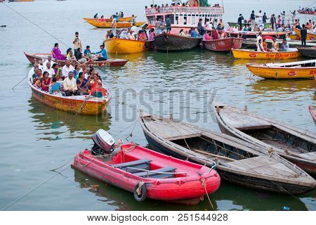 VARANASI, UTTAR PRADESH, INDIA - JULY 6, 2018: Boats with pilgrims arriving at ceremonies Dasashvamedh Ghat 