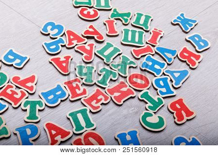 Colourfull Letters Of The Alphabet Are Chaotically Arranged On The White Background.