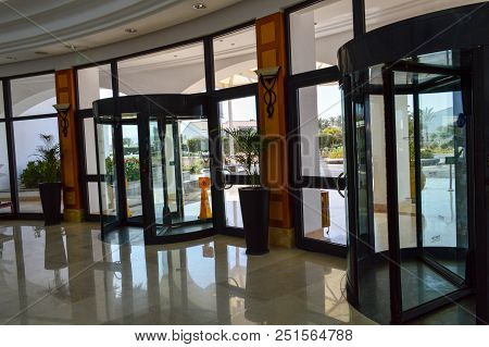 A Revolving Glass Door To The Shopping Center, A Building, A Three-door Structure Anchored On The Ce