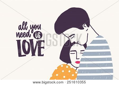 Embracing Young Man And Woman And All You Need Is Love Lettering Handwritten With Elegant Font. Hugg