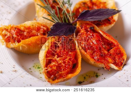 Italian Pasta Conchiglioni Rigati Stuffed With Dry Tomatoes And Meat. Sprinkled With Cheese.