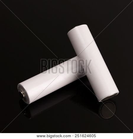 Two White Batteries On A Glass Table.