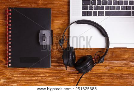 Top View Laptop Headphones Diary Book On Dark Vintage Wooded Table