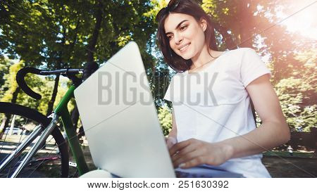 Cute Romantic Girl With Green Bicycle Sitting On Beanch And Working With Laptop In The Sunny Summer 