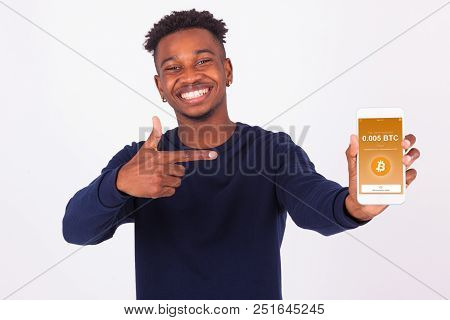 Young African American Man Pointing His Smartphone Screen  Showing A Received Crypto Currency Transa